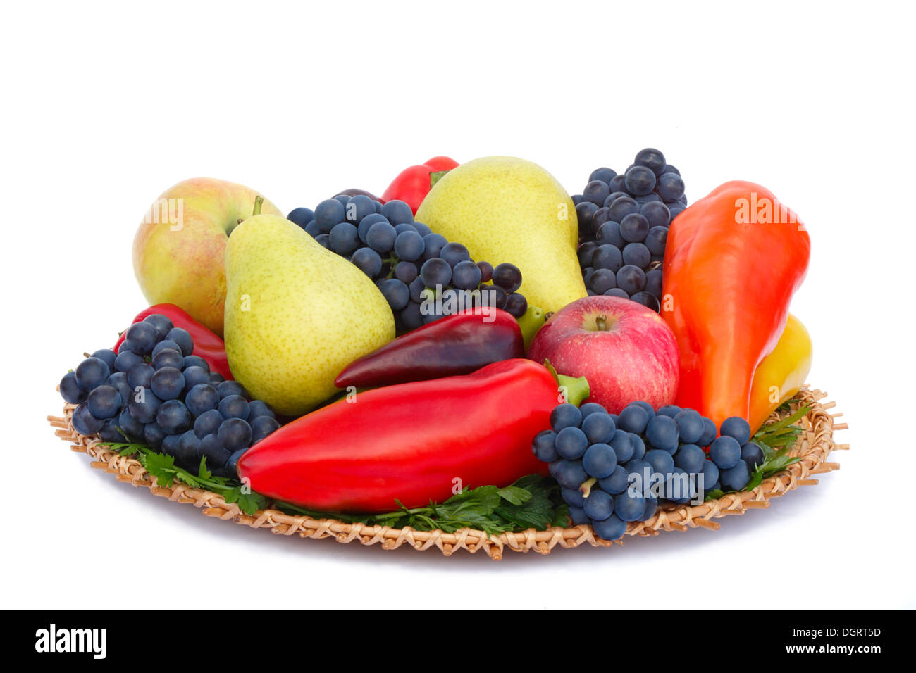 Pere mature , le mele, uva e pepe su un piatto. Presentato su uno sfondo bianco. Foto Stock