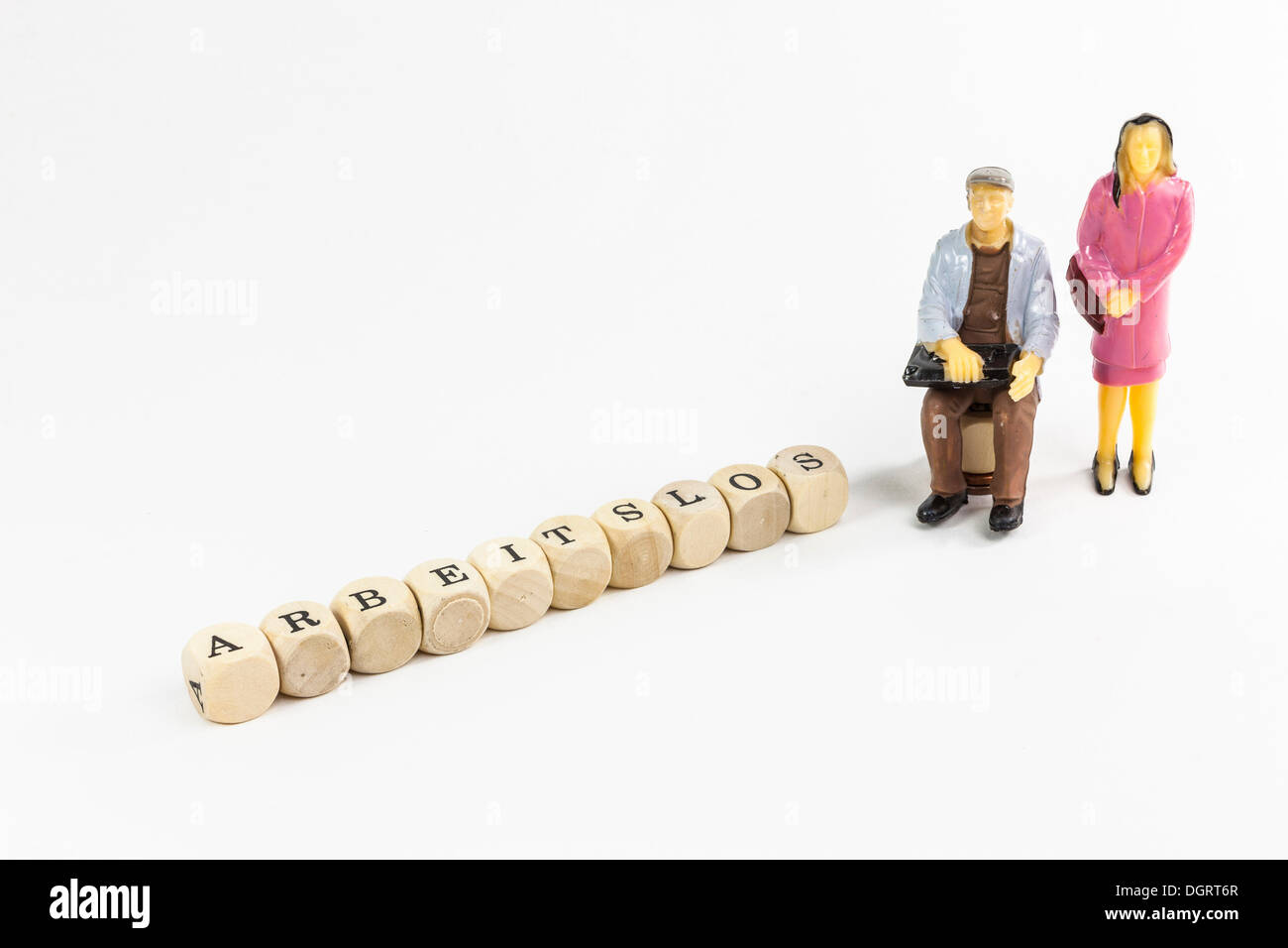 Le figure in miniatura di un disoccupato giovane, lettera cubi formanti la parola 'arbeitslos', tedesco per "disoccupati" Foto Stock