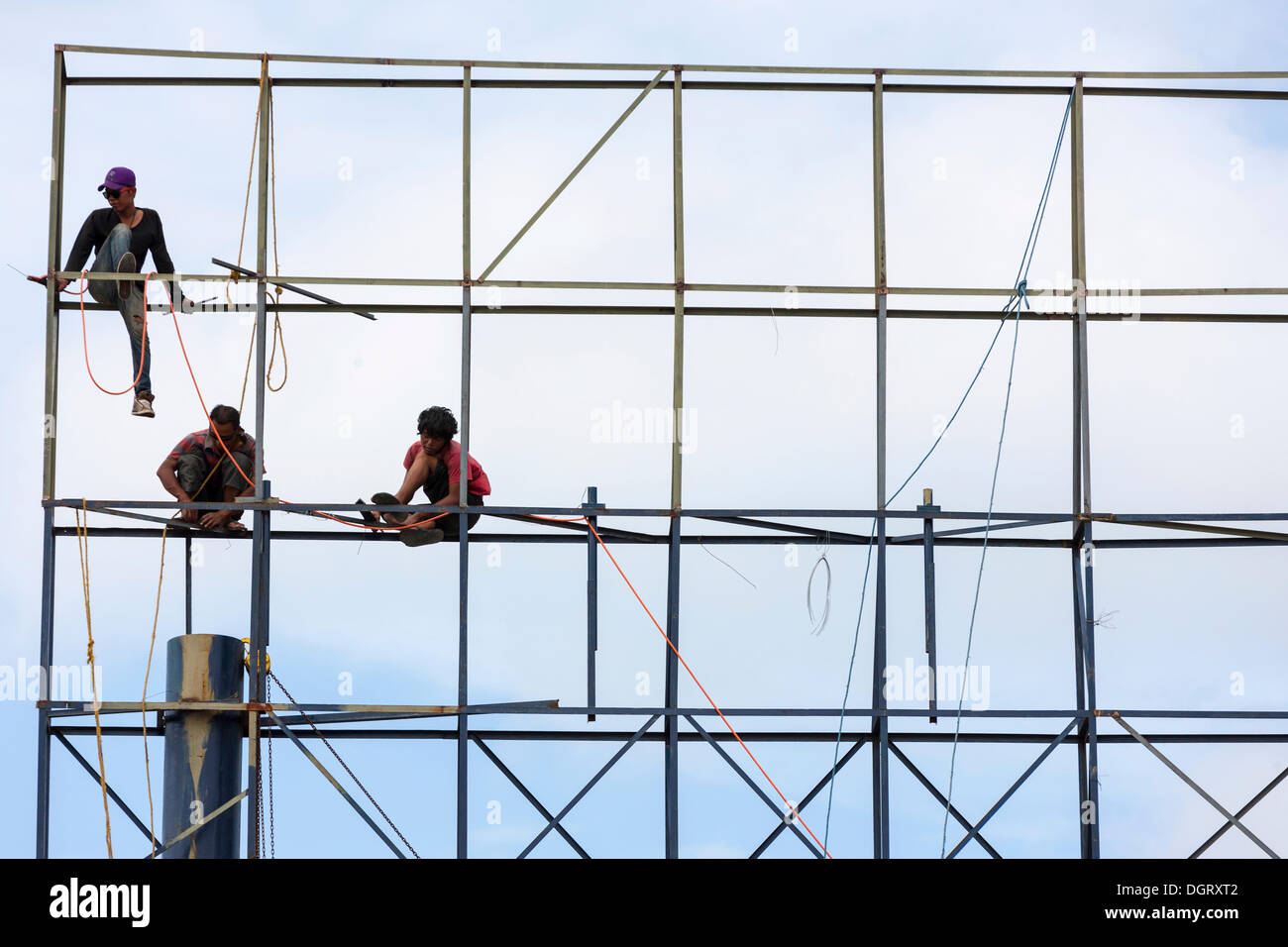 I lavoratori non protetti assemblare una impalcatura, Banjar Kertabuana, Denpasar, Bali, Indonesia Foto Stock