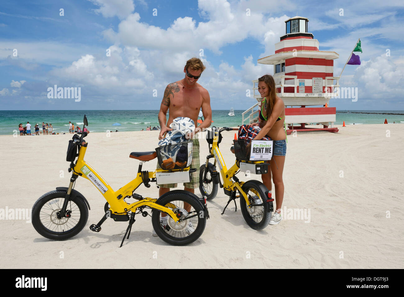 Coppia con biciclette elettriche, Torre di Guardia, il molo, Miami Torre di salvataggio, South Beach, Miami, Florida, Stati Uniti d'America Foto Stock