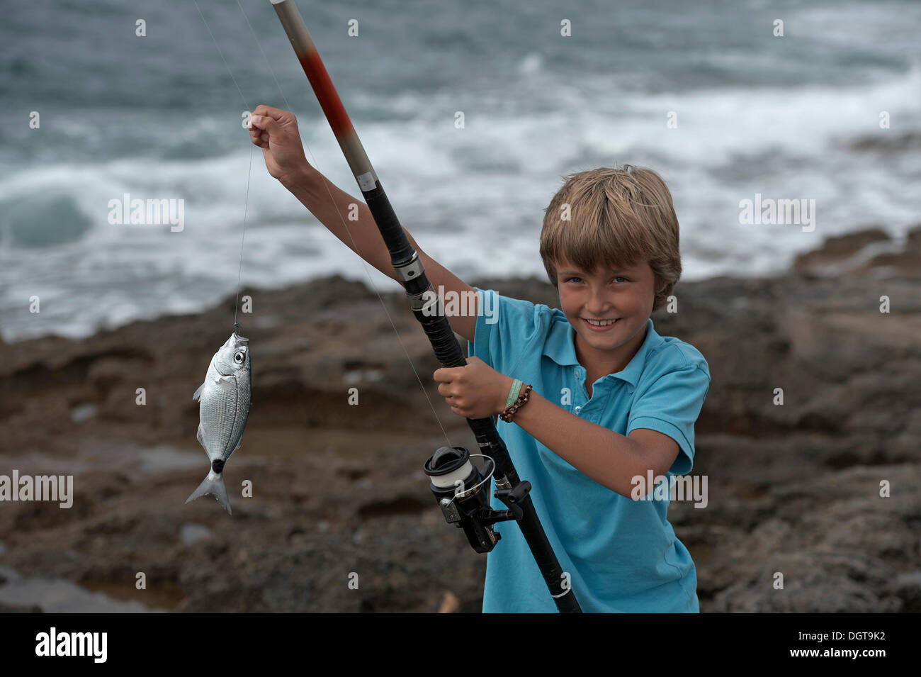 Ragazzo con un pesce pescato, Sant Antoni, Ibiza, Pitiusic isole o isole di pino, isole Baleari, Spagna, Europa Foto Stock