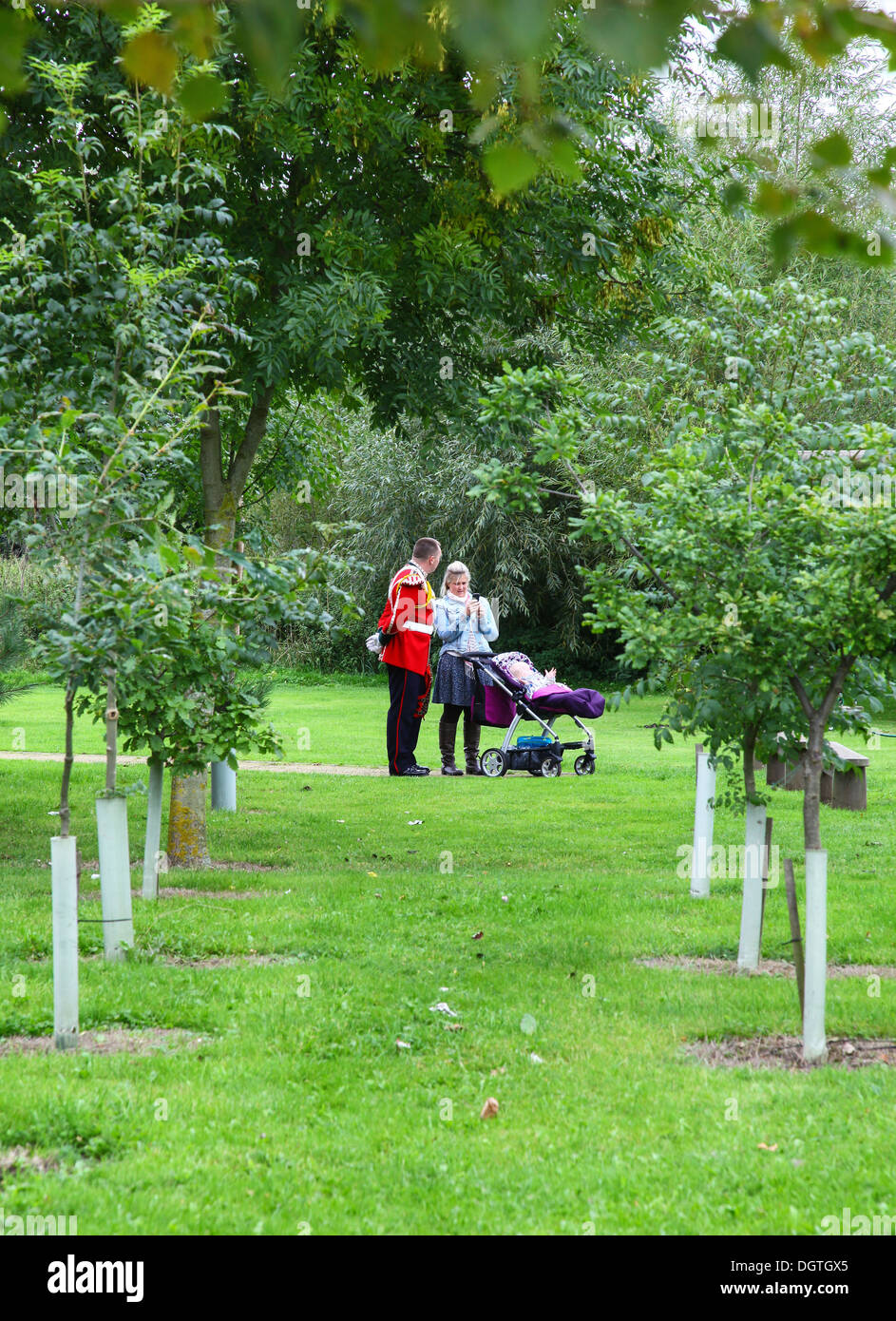 Un soldato vestito in uniforme con la moglie o il partner e il bambino in una sedia push presso il National Memorial Arboretum, vicino a Lichfield, Staffordshire, Foto Stock