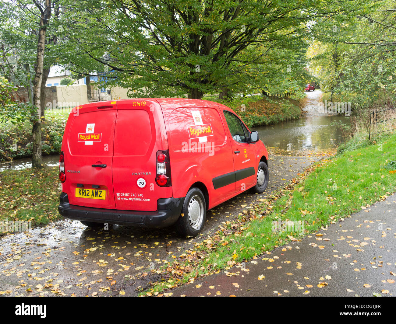 Smart clean bright red Royal Mail post furgone parcheggiato da una Ford su un piccolo fiume in autunno Foto Stock