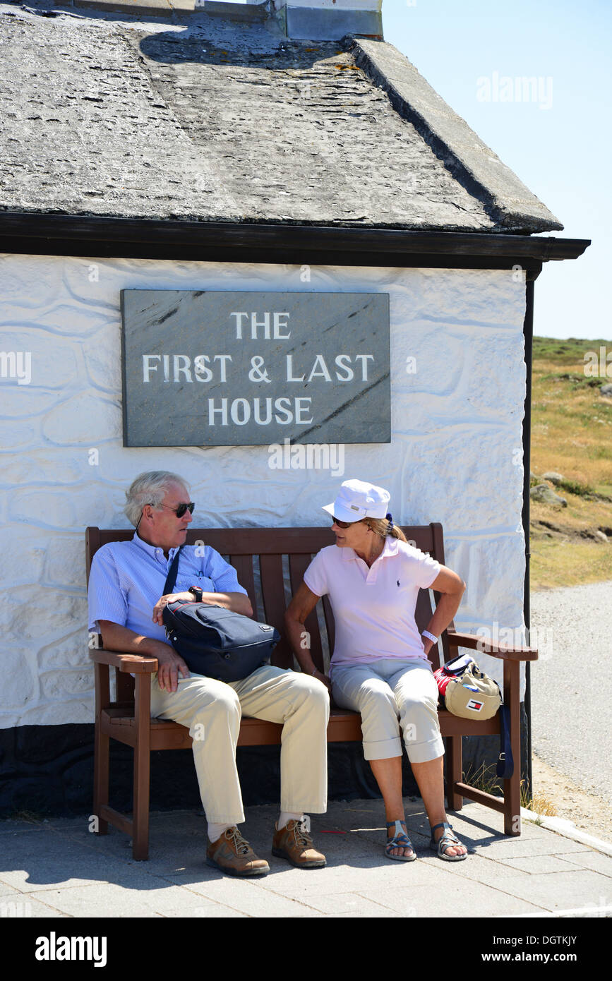 Giovane seduto fuori " il primo e ultimo House', Land's End, penisola di Penwith, Cornwall, England, Regno Unito Foto Stock