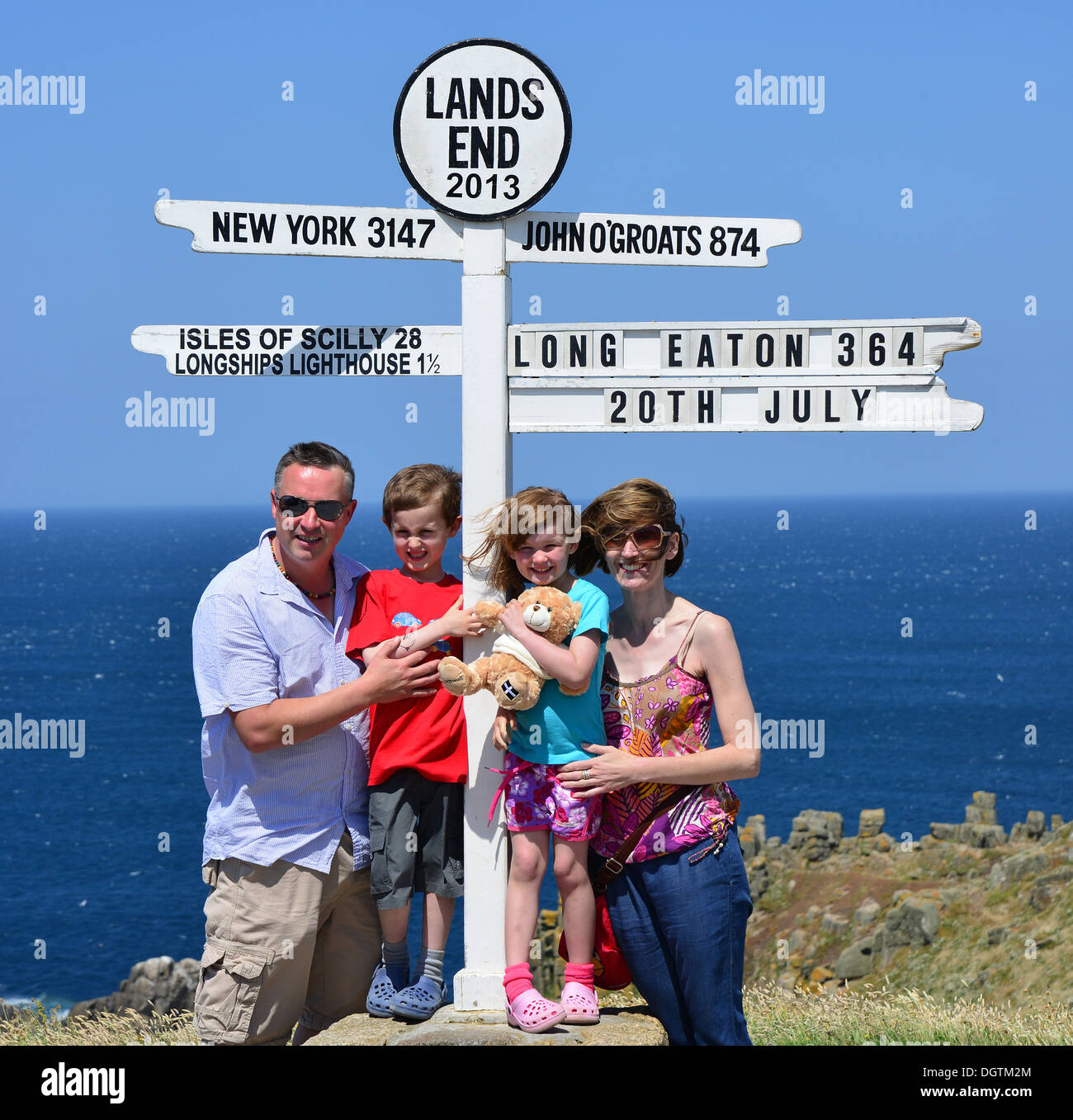 Foto di famiglia a distanza cartello al Land's End, penisola di Penwith, Cornwall, England, Regno Unito Foto Stock