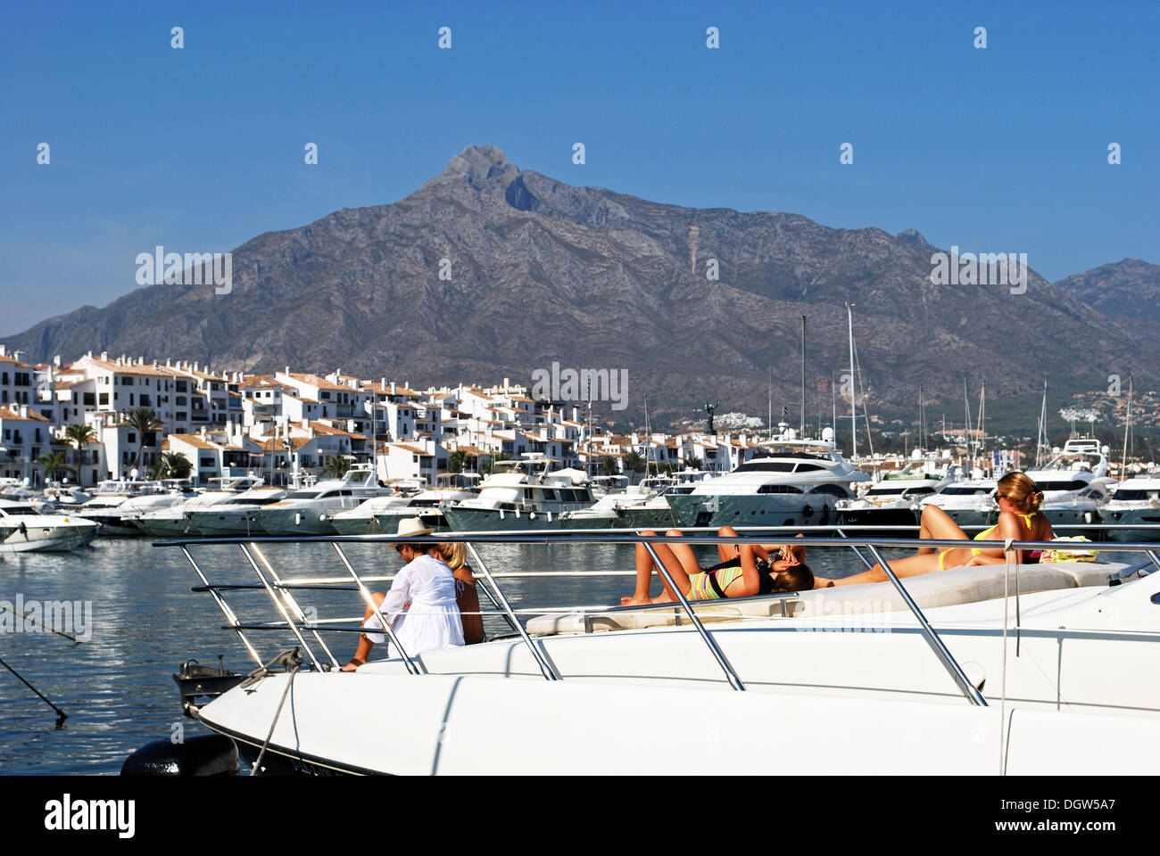 I giovani a prendere il sole su una barca nel porto di Puerto Banus a Marbella, Costa del Sol, provincia di Malaga, Andalusia, Spagna. Foto Stock