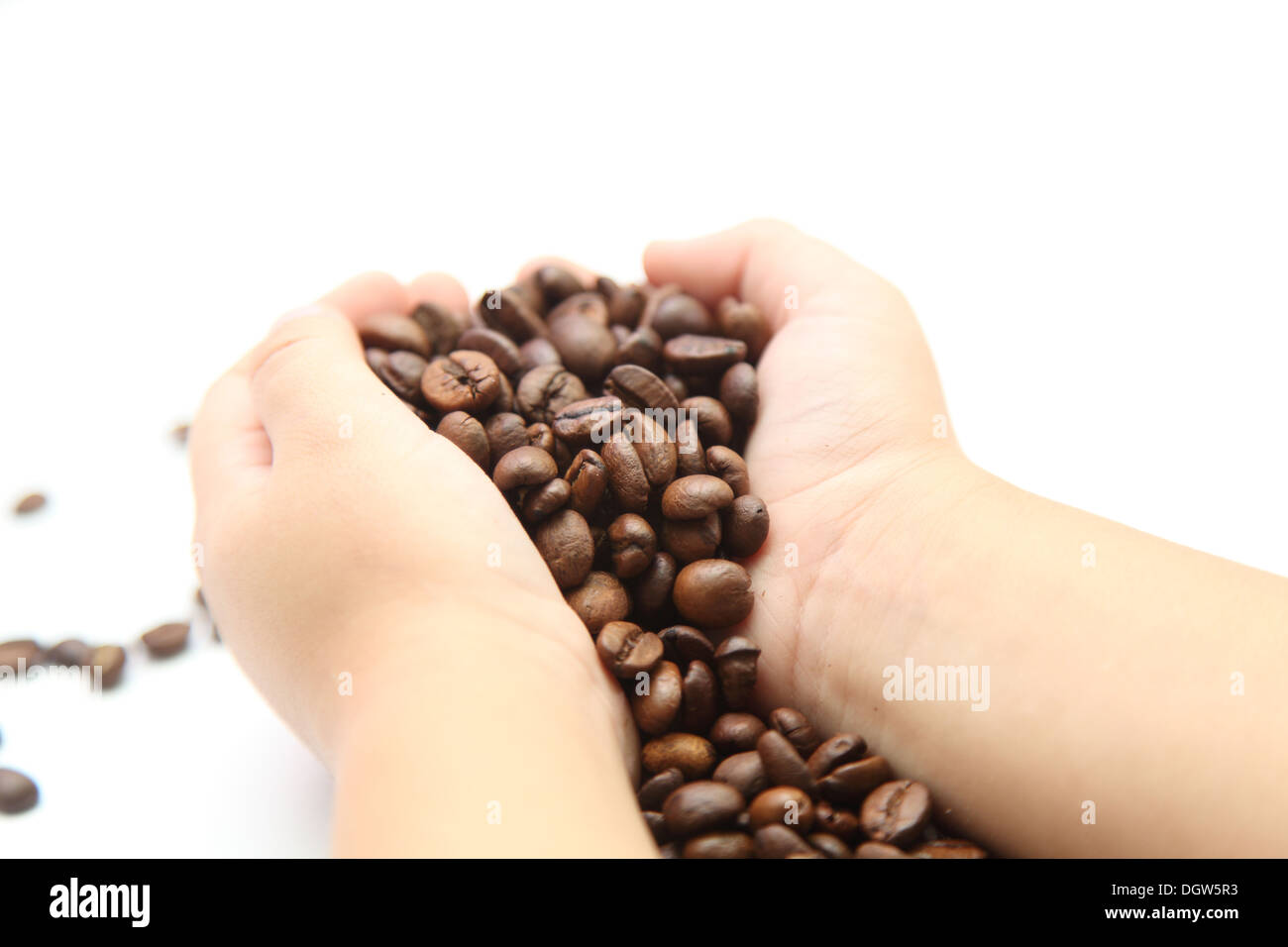 I chicchi di caffè nelle mani di un bambino Foto Stock