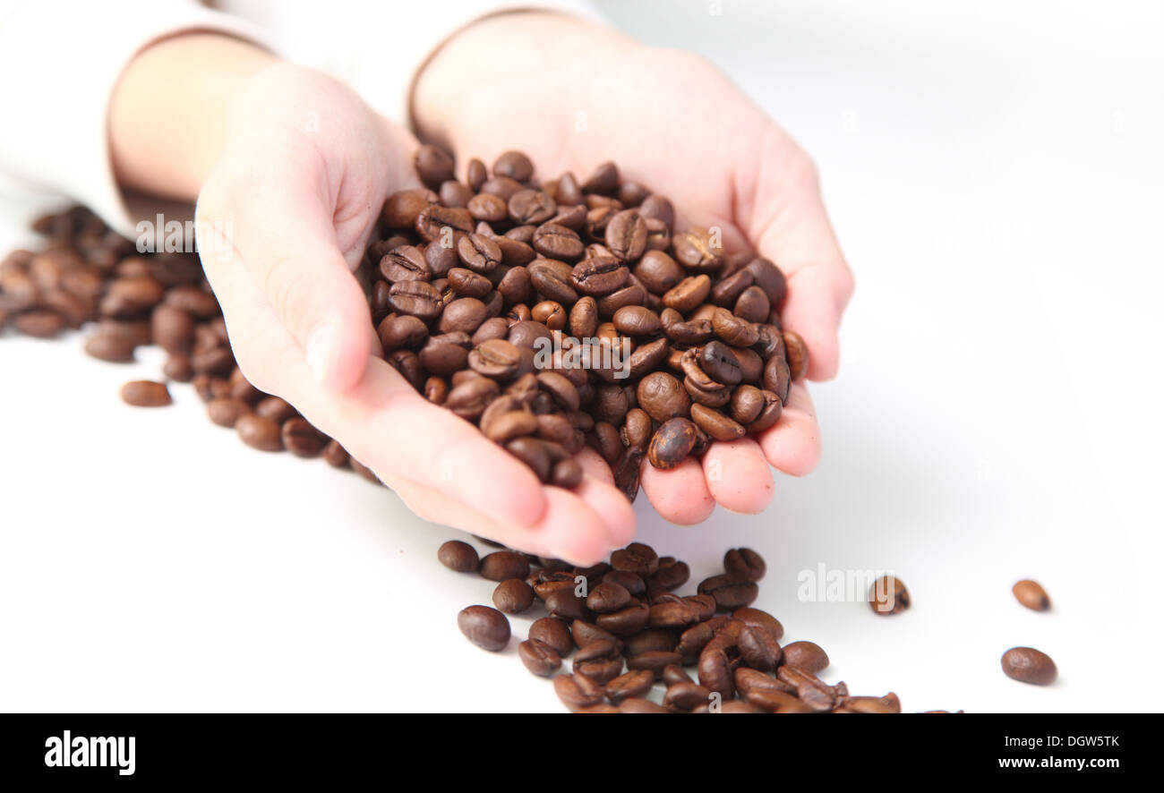 I chicchi di caffè nelle mani di un bambino Foto Stock