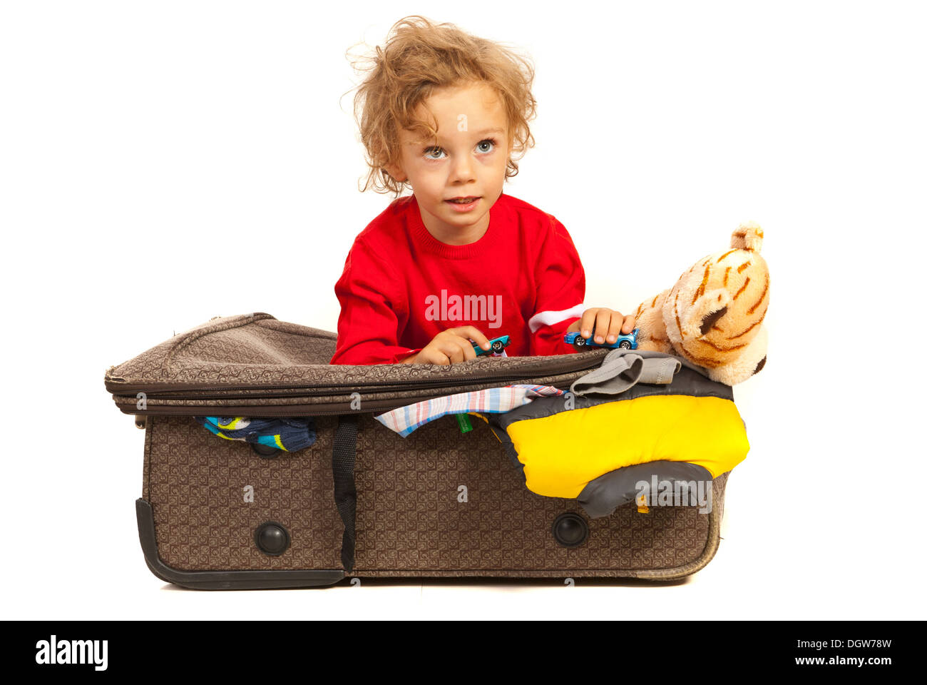 Il Toddler boy dreaming in vacanza e seduti sui bagagli Foto Stock