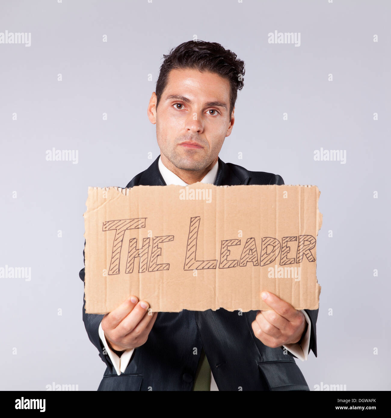 Giovane imprenditore tenendo un pezzo di cartoncino dicendo che lui è il leader Foto Stock