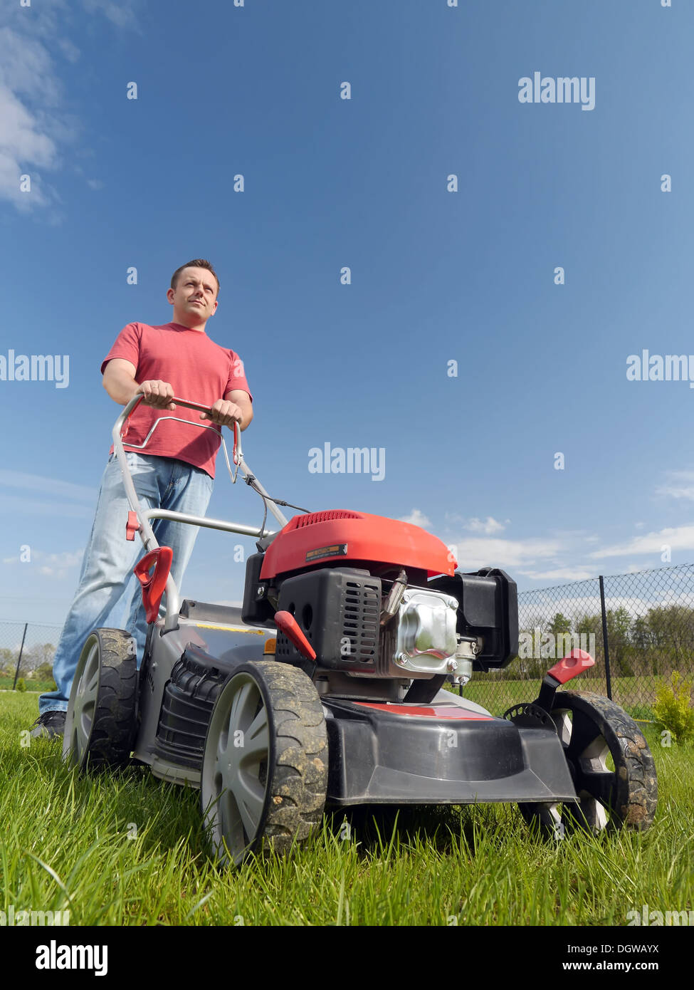 L'uomo la falciatura di erba nel suo cortile con erba-rasaerba Foto Stock