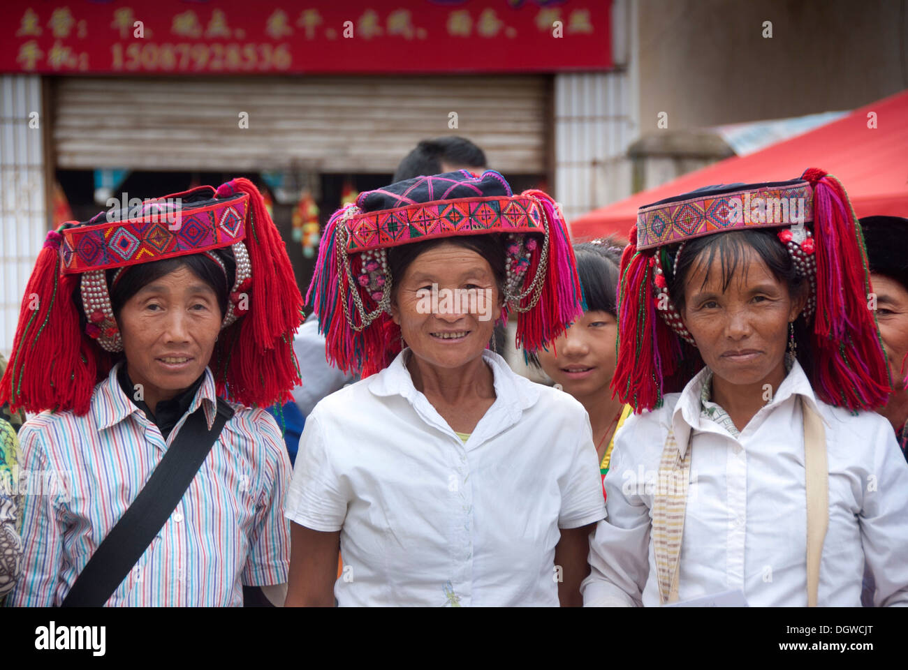 Tre donne di Yi o Hani minoranza etnica indossando headware colorati in un festival, Jiangcheng, Pu'er City, nella provincia dello Yunnan Foto Stock