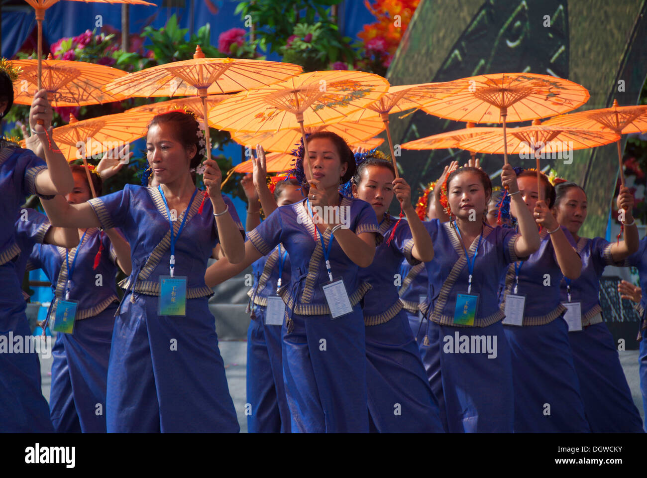 Festival Etnico, spettacolo di danza per le donne dal Vietnam, abiti blu, arancione ombrelloni, Jiangcheng, Pu'er City, nella provincia dello Yunnan Foto Stock