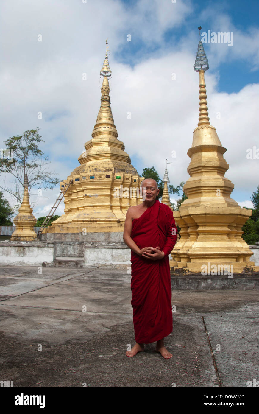 Il Buddismo Theravada, stupa dorato, monaco in rosso accappatoi, che Xieng Tung, Muang cantare, Luang Namtha Provincia, Sipsongpanna, Laos Foto Stock