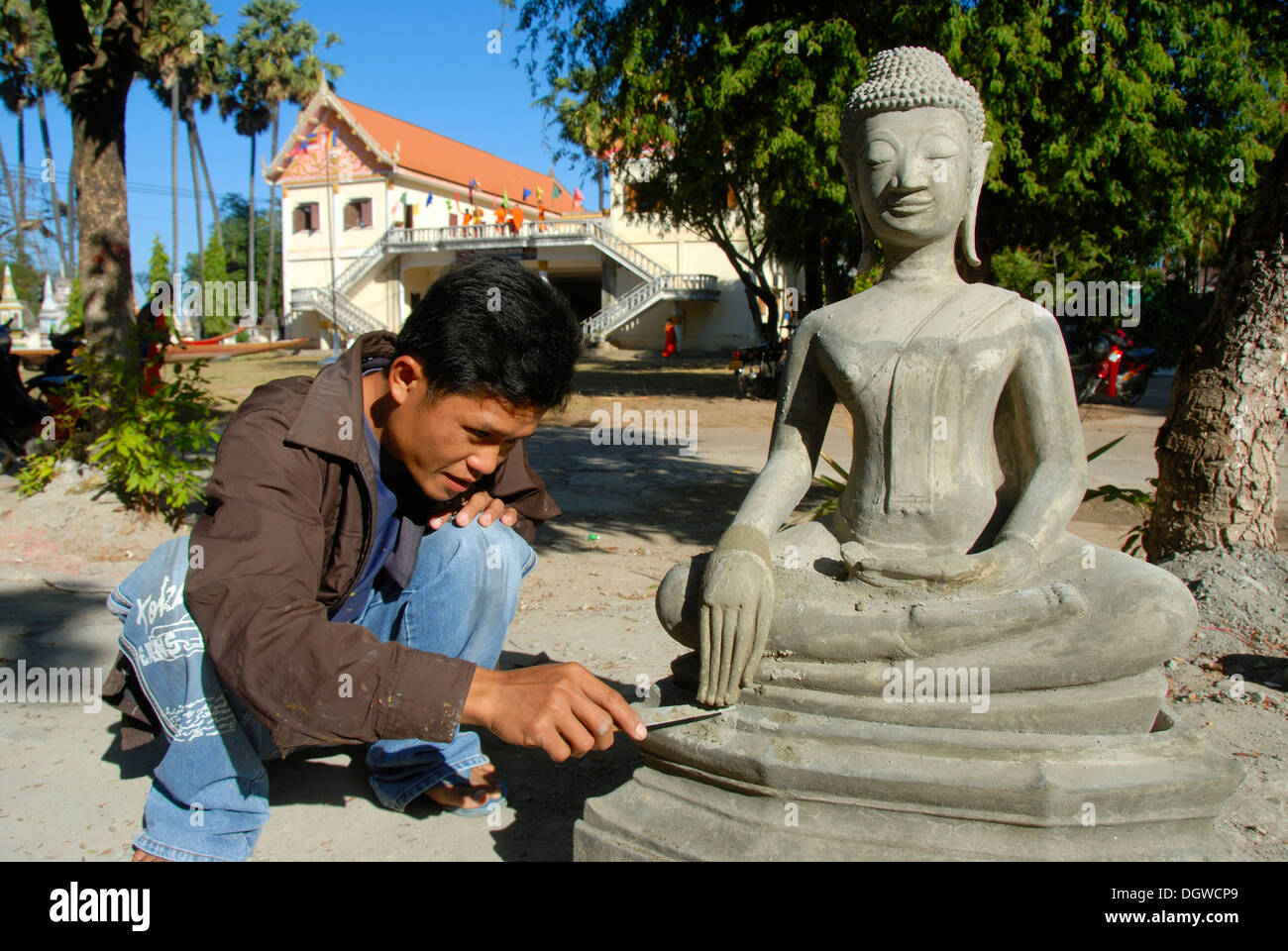 Il Buddismo Theravada, scalpellino, lavorando su un delicato dettaglio, le dita, le mani di una statua del Buddha, Wat Xayaphoum tempio Foto Stock