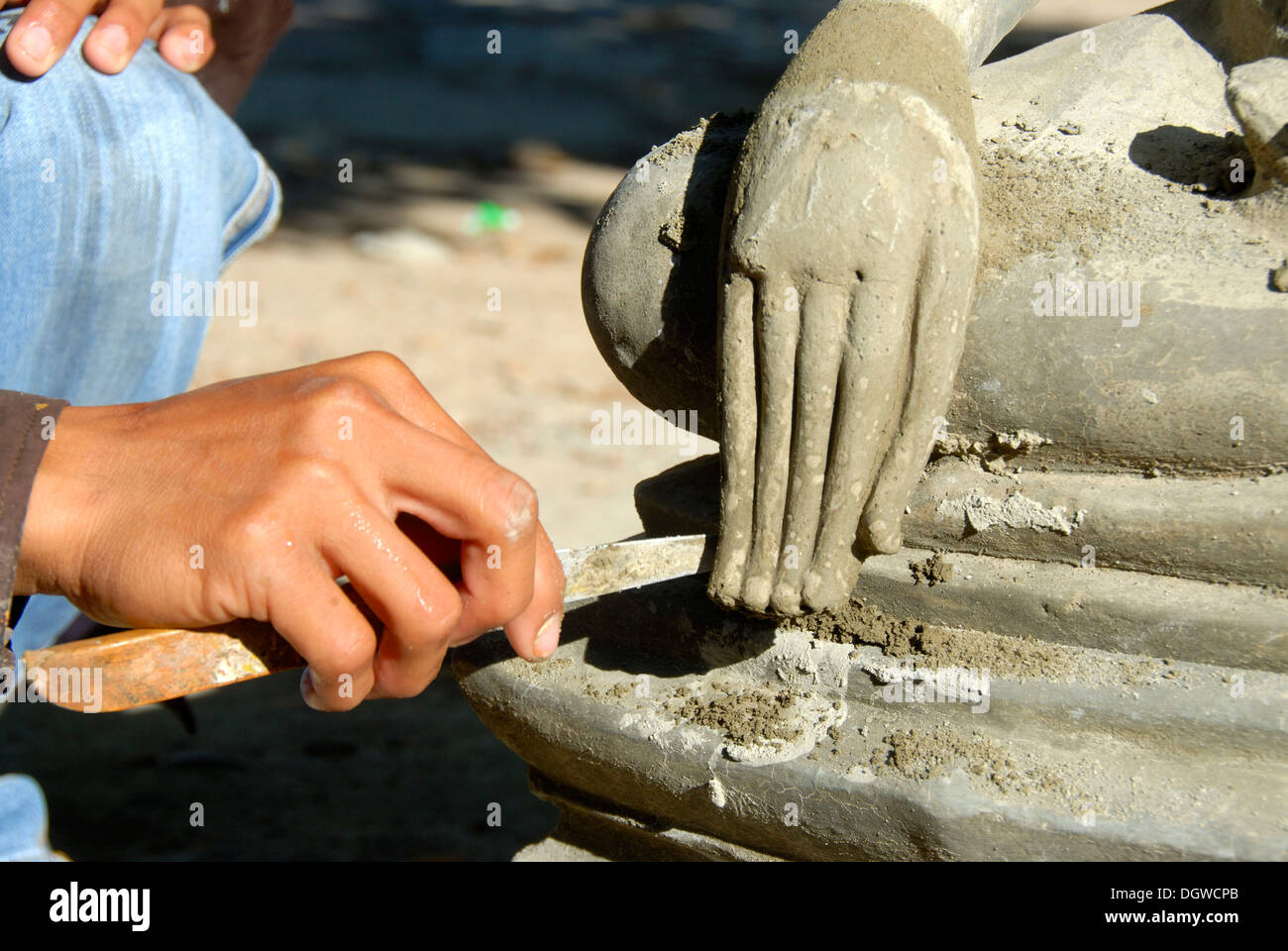 Il Buddismo Theravada, scalpellino, lavorando su un delicato dettaglio, mano di una statua del Buddha, Wat Xayaphoum tempio, Savannakhet, Laos Foto Stock