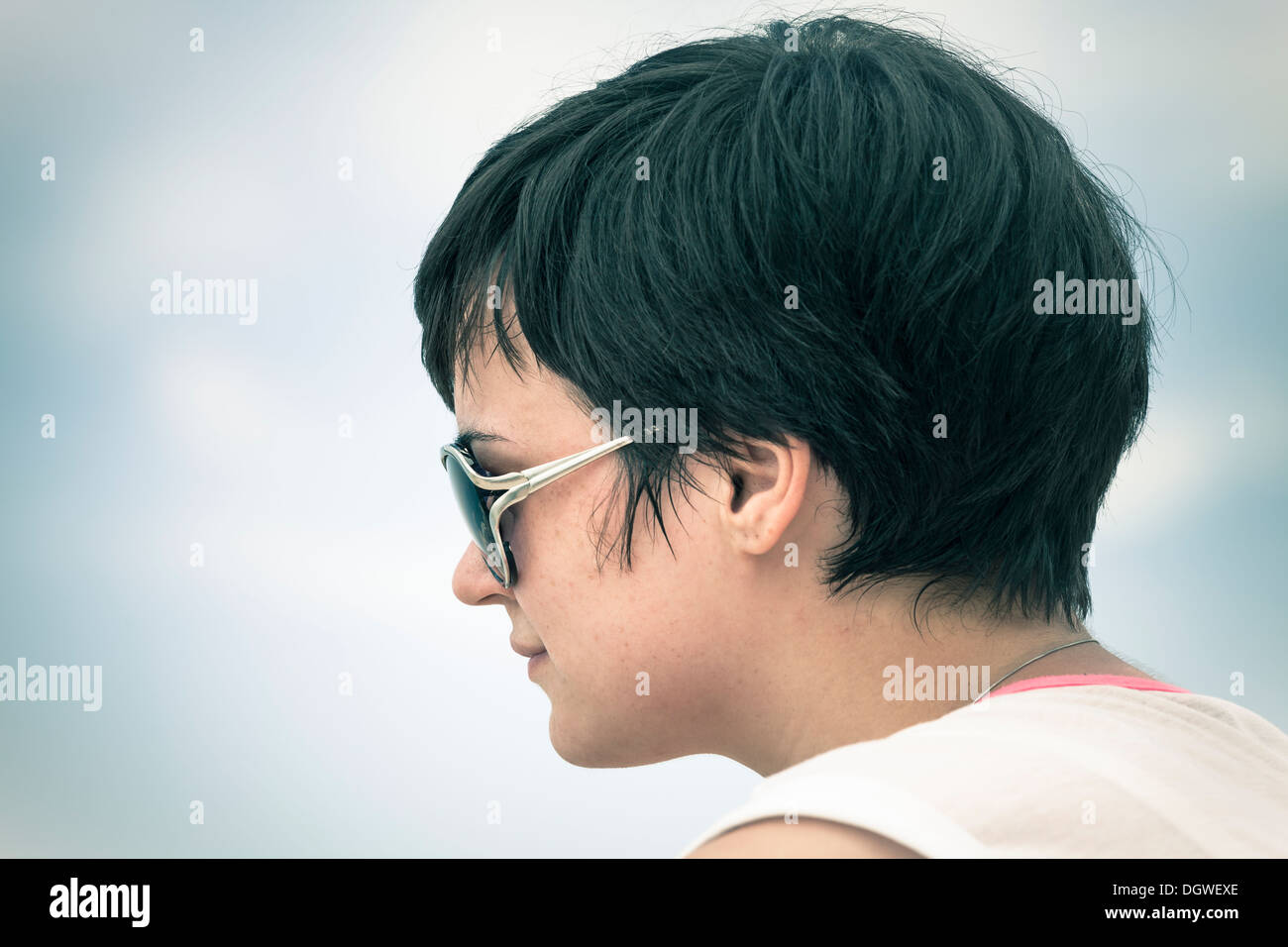 Profilo di giovane donna faccia in occhiali da sole oltre il cielo. Foto Stock