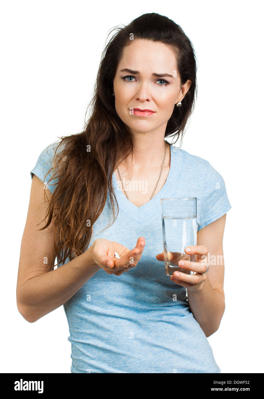Un infelice Donna del dolore tenendo un bicchiere di acqua e killer del dolore pillola, guardando la fotocamera. Isolato su bianco. Foto Stock