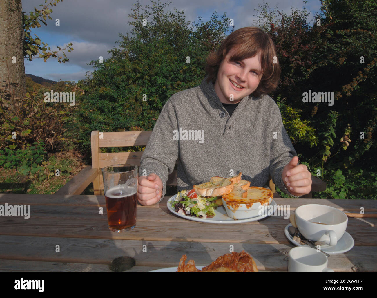 Un 18yr old adolescente di mangiare un pasto da pub. Foto Stock