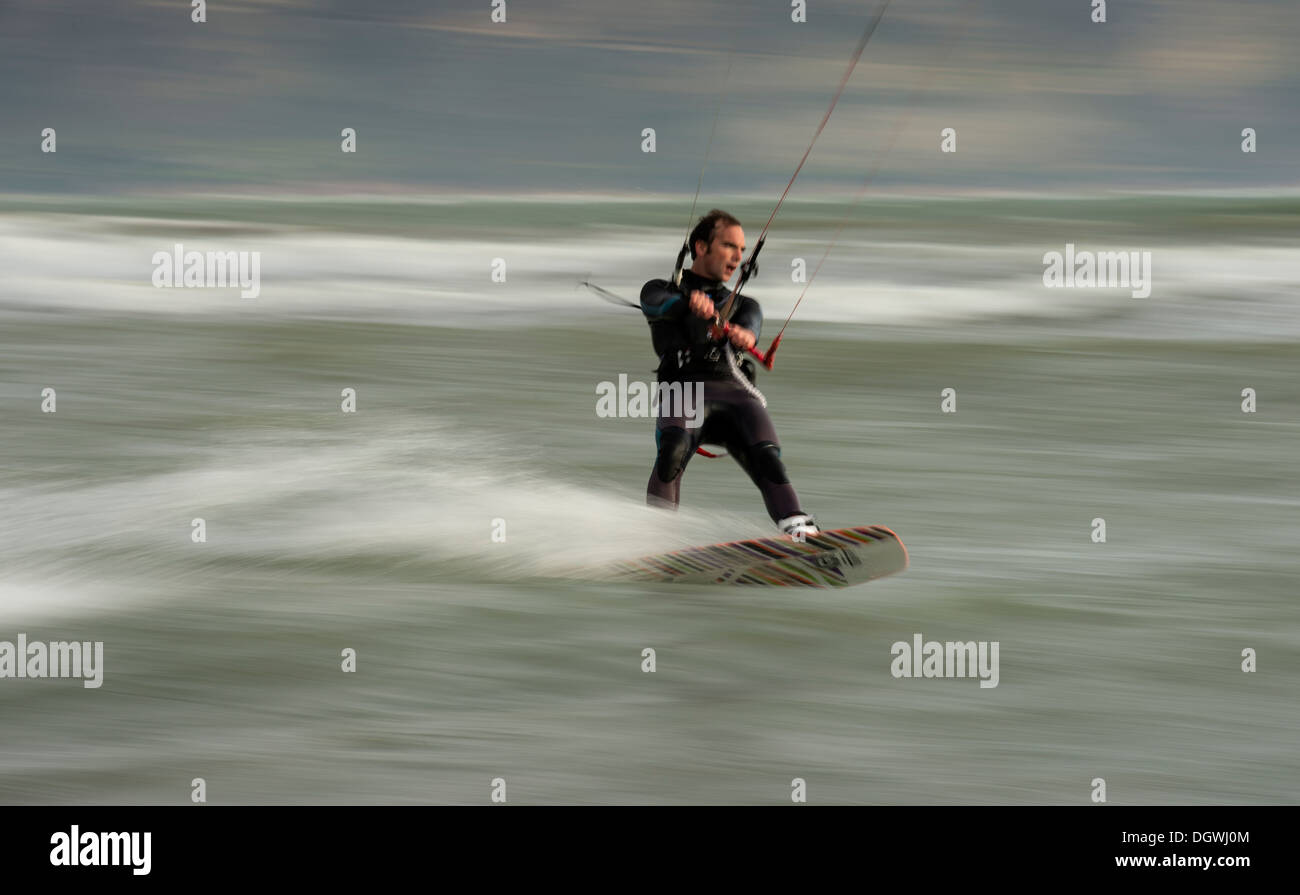 Kitesurfer cavalcando le onde, panning shoot Foto Stock
