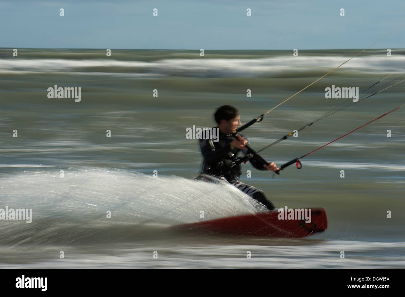 Kitesurfer cavalcando le onde panning shoot Foto Stock
