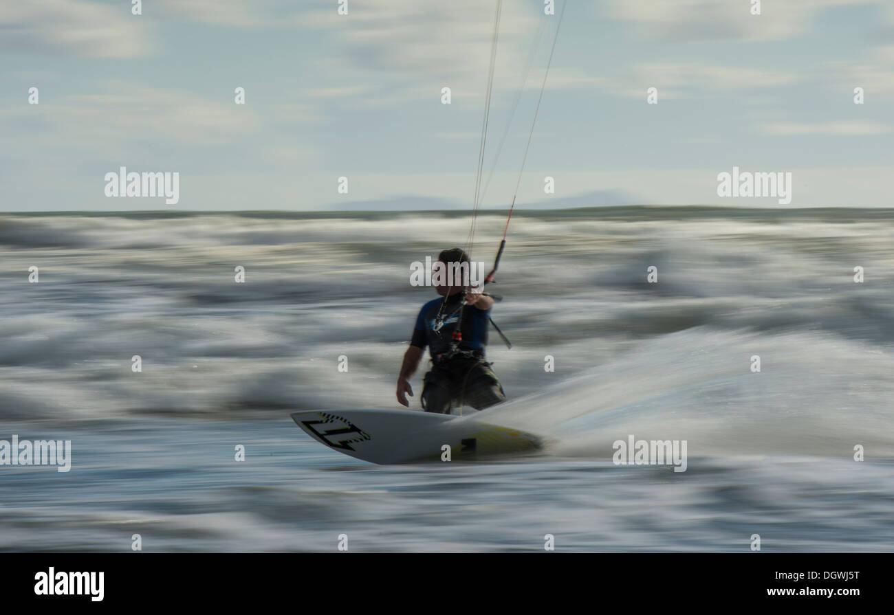 Kitesurfer cavalcando le onde panning shoot Foto Stock