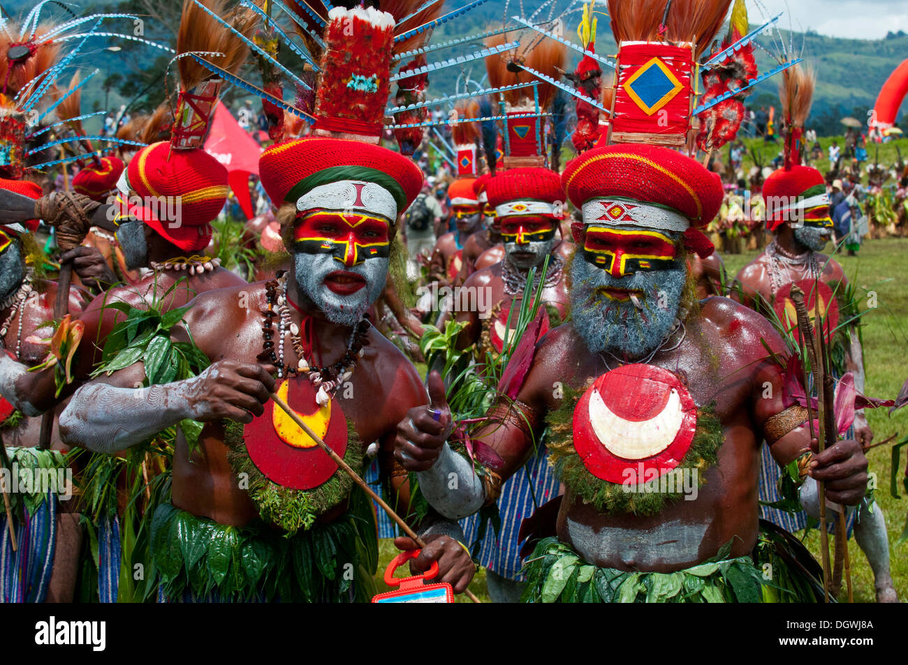 I membri di una tribù in colori vivaci costumi decorati con vernice di faccia al tradizionale sing-sing raccolta, Hochland Foto Stock