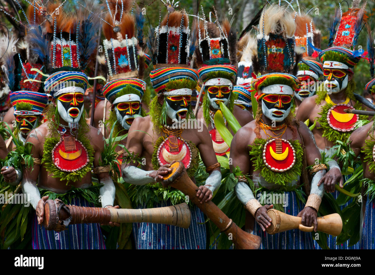 Gli uomini in colori vivaci costumi decorati con vernice faccia si celebra presso il tradizionale cantare cantare la raccolta nelle highlands Foto Stock