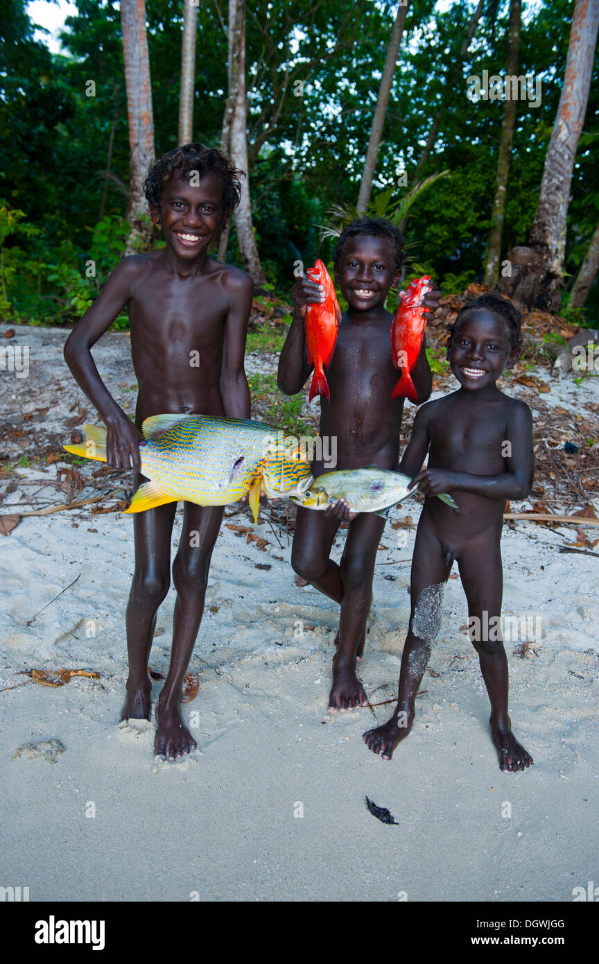 Ragazzi che mostra con orgoglio il pesce pescato, Marovo Lagoon, provincia occidentale, Isole Salomone Foto Stock