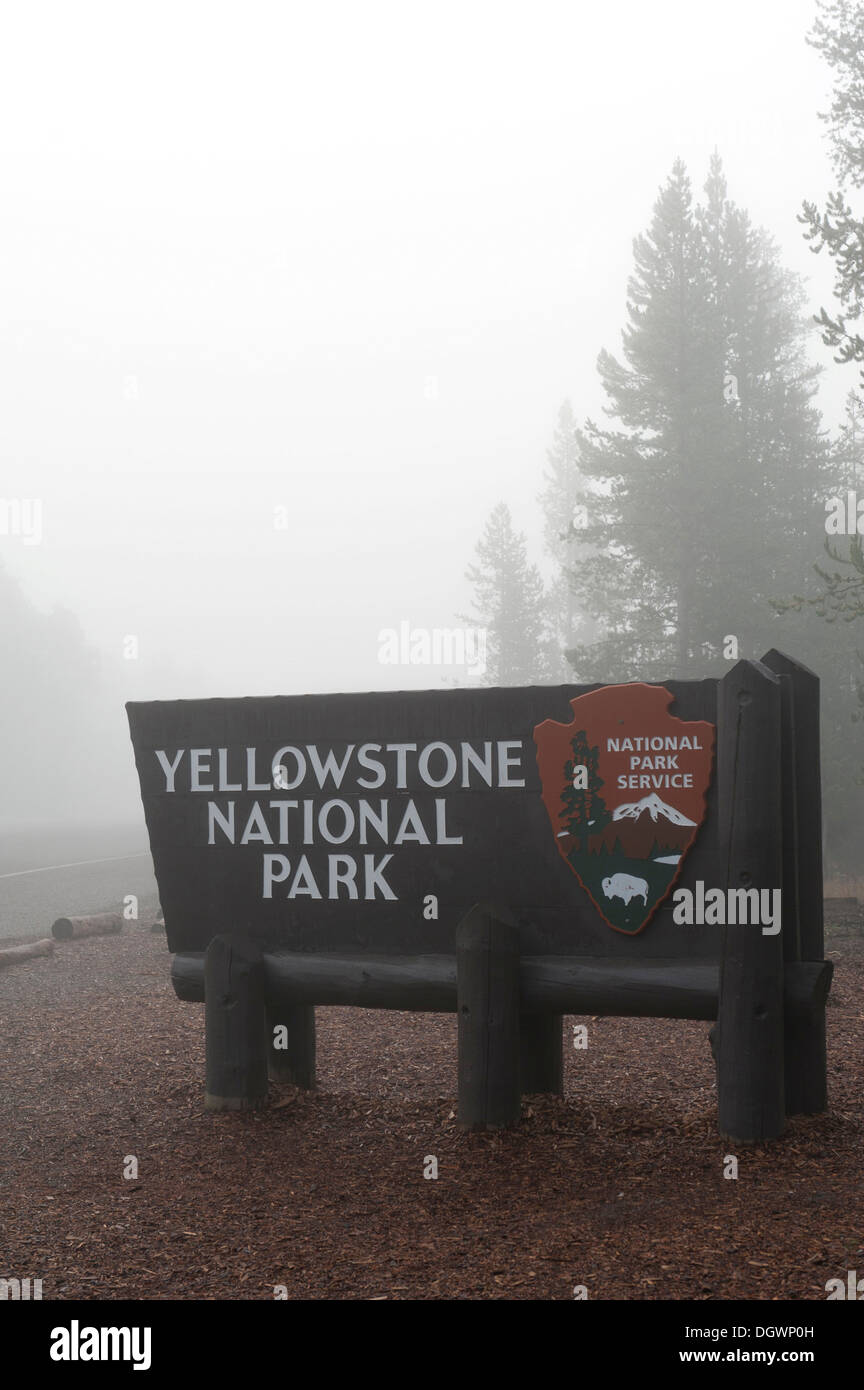 Ingresso, cartello in legno nella nebbia, National Park Service, Ingresso Ovest, il Parco Nazionale di Yellowstone, West Yellowstone, Montana Foto Stock