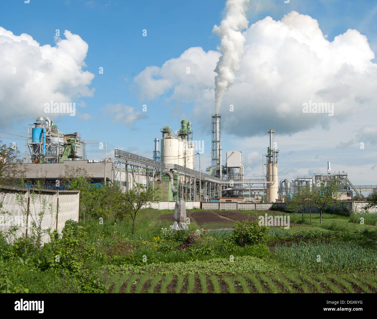 Il fumo della fabbrica, inquinando l'aria con il cielo nuvoloso Foto Stock