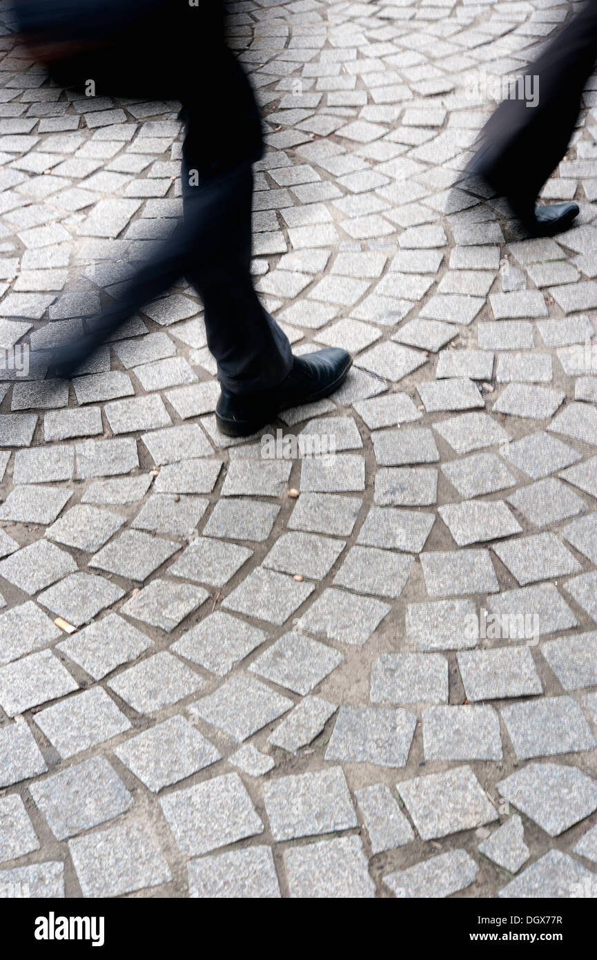 Movimento dei pendolari piedi (sfocata), camminare sul marciapiede in ciottoli - scena da Mumbai, la capitale commerciale dell India Foto Stock
