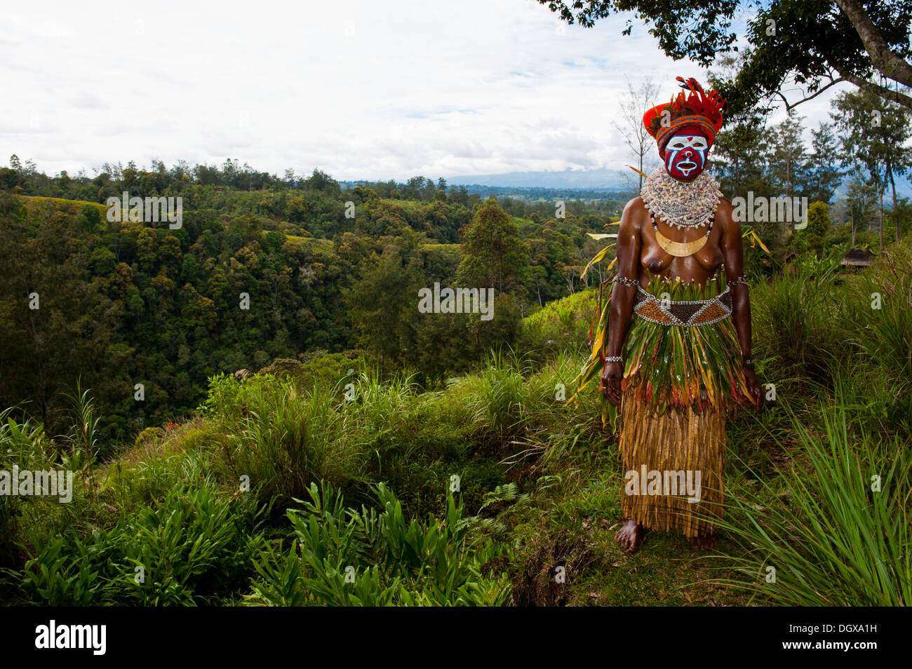 Una donna con il colorfully decorato costume e faccia la vernice è festeggiato presso il tradizionale cantare cantare la raccolta nelle highlands Foto Stock