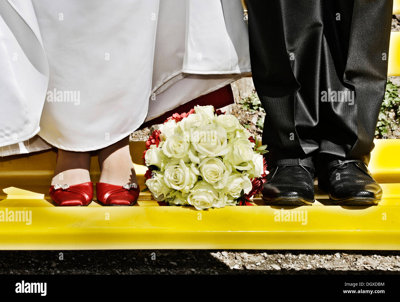 Bouquet nuziale che giace tra i piedi della sposa e lo sposo Foto Stock