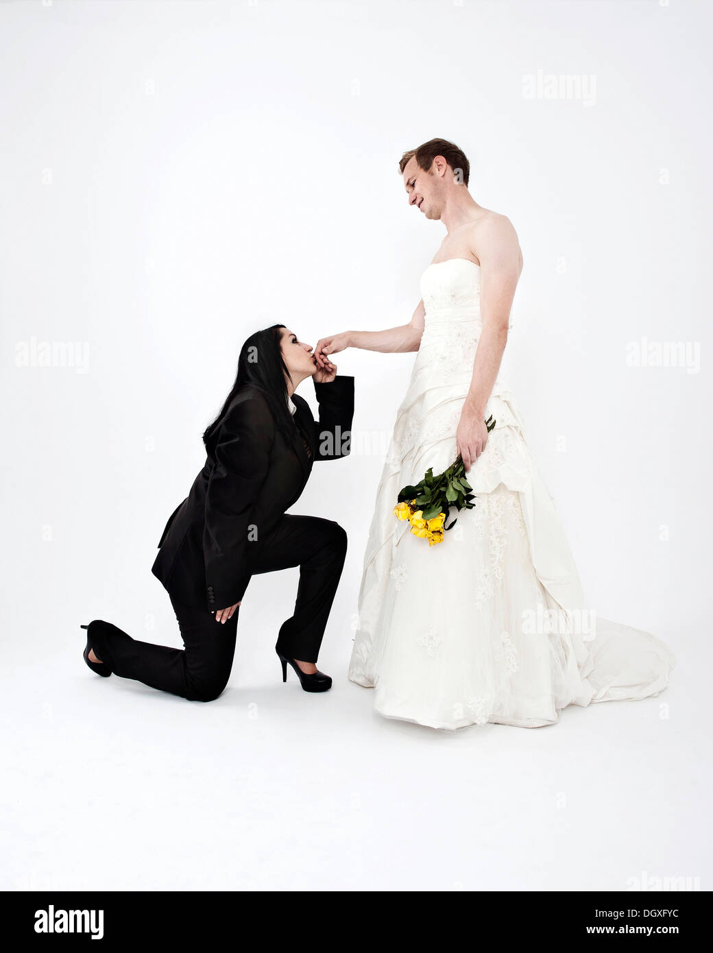 Sposa indossa una tuta di baciare la mano di uno sposo che indossa un abito da sposa, scambio di abiti nuziali, Austria Foto Stock