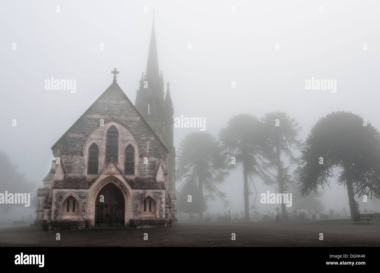 Vecchia chiesa in un inquietante cimitero di nebbia Foto Stock