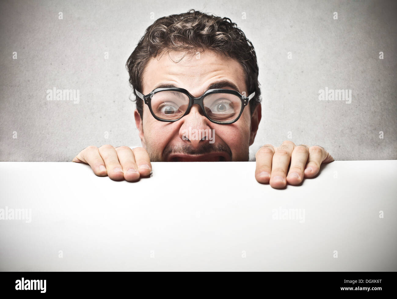 Uomo con occhiali tenendo un cartone Foto Stock