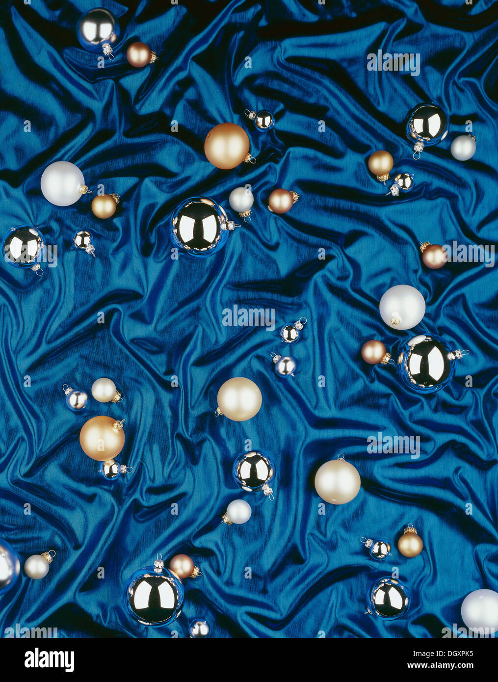 Christmas baubles giacente su un blu panno di seta Foto Stock