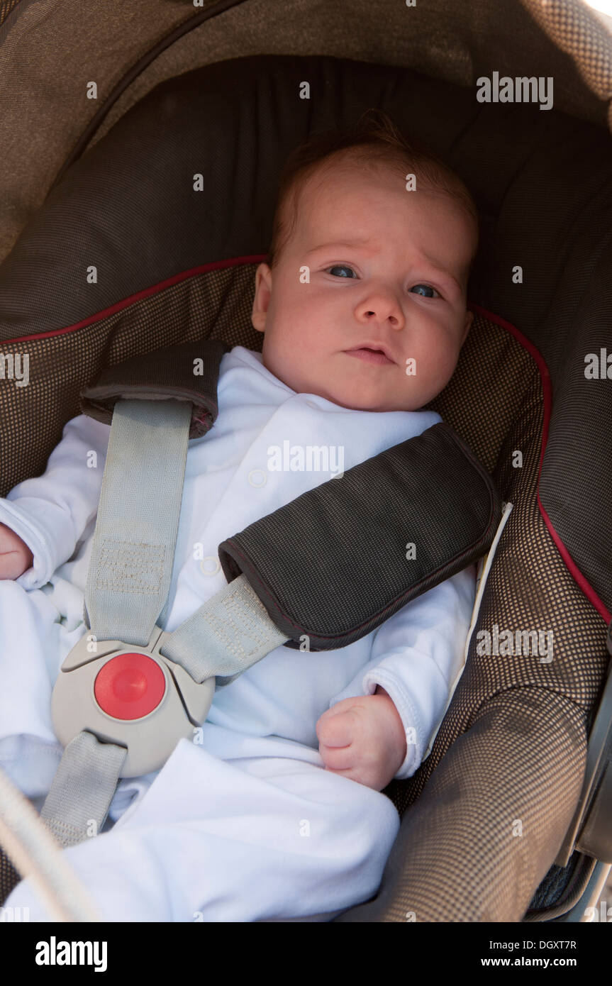 Little Baby girl strapped nel suo passeggino Foto Stock