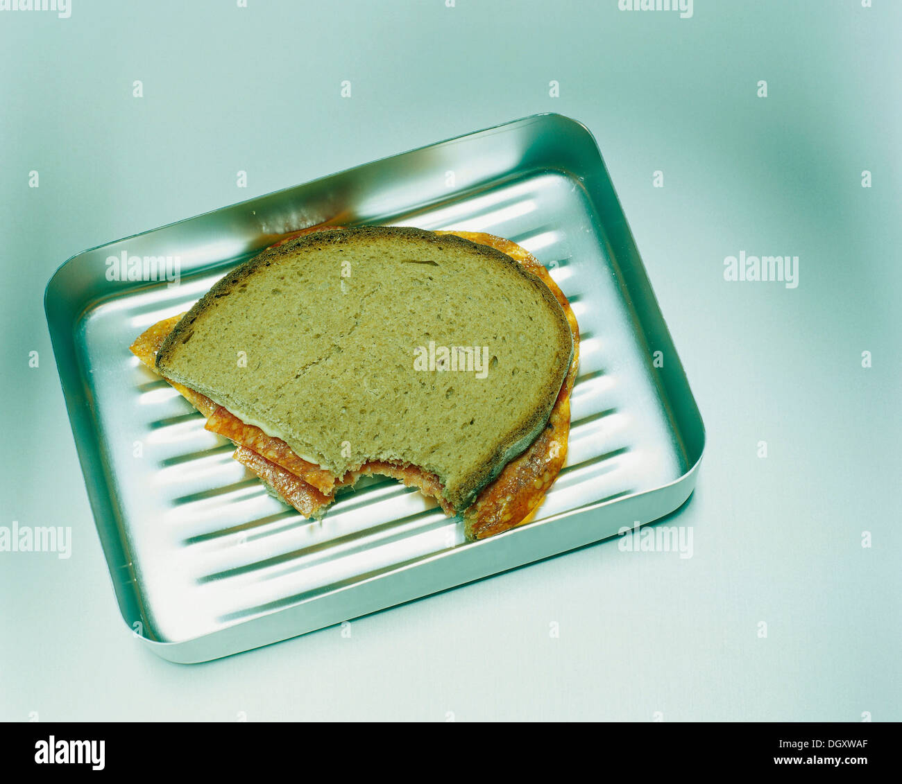 Semi-mangiato salami sandwich in un alluminio scatola di pranzo Foto Stock