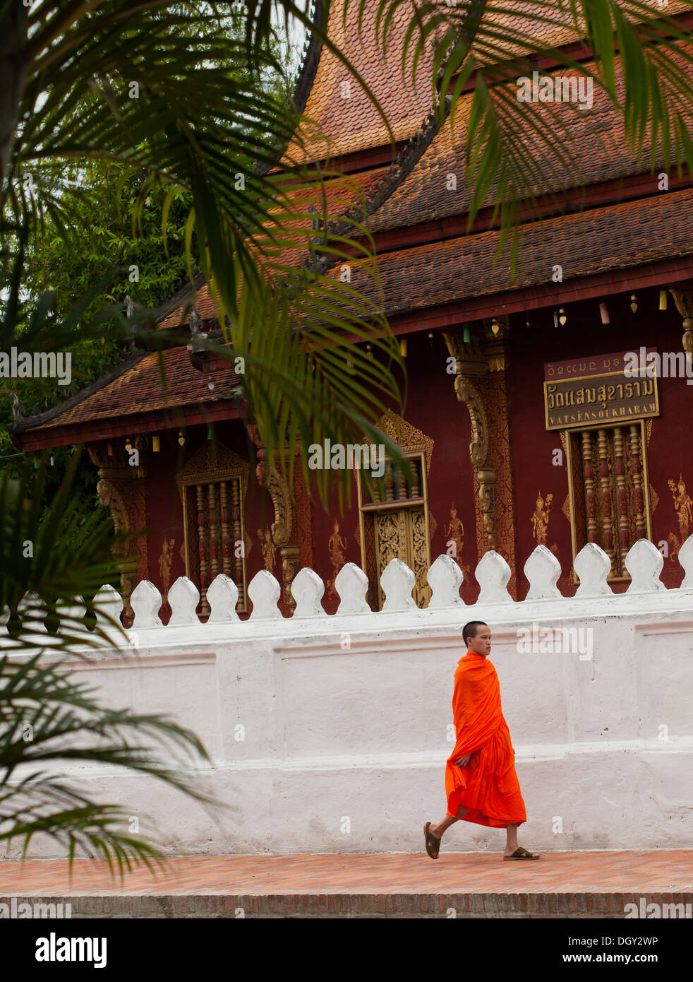 Un monaco buddista placcati in arancione da passeggiate il Wat Sen tempio buddista a Luang Prabang, Laos. Foto Stock