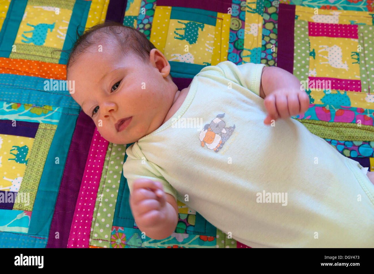 Little Baby girl sdraiato su un variopinto mosaico Foto Stock