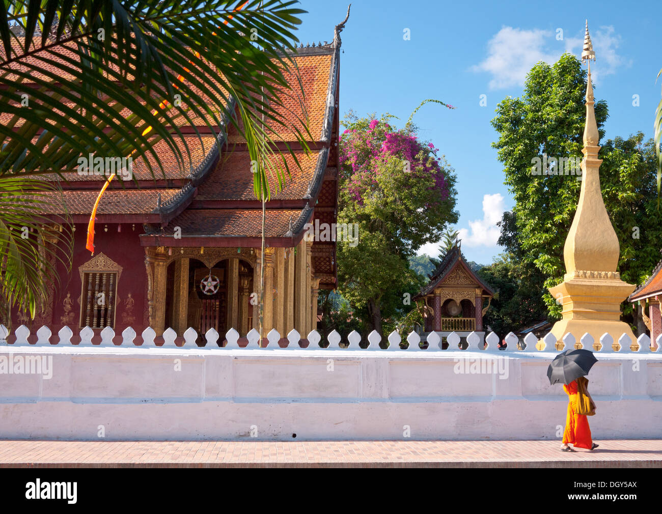 Un monaco buddista passeggiate con il Wat Sen Tempio a Luang Prabang, Laos. Foto Stock