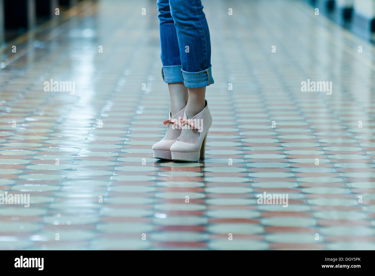 Primo piano della donna in piedi sulla colorata piastrelle del pavimento Foto Stock