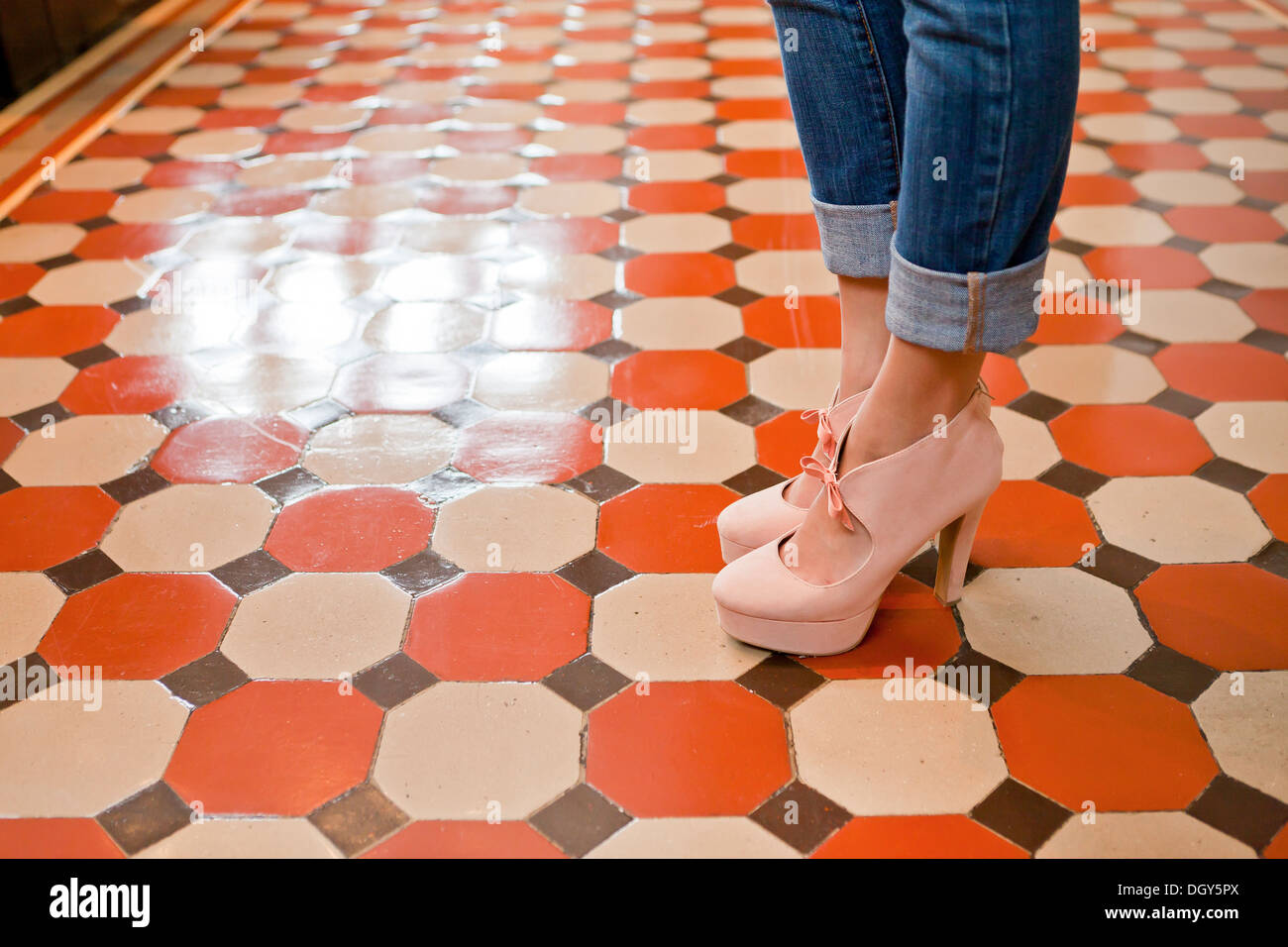 Primo piano della donna in piedi sulla colorata piastrelle del pavimento Foto Stock