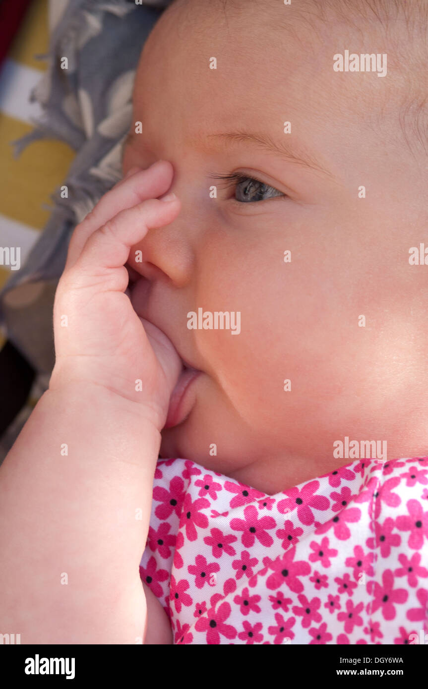 Close-up di una piccola bambina succhiare il suo pollice Foto Stock