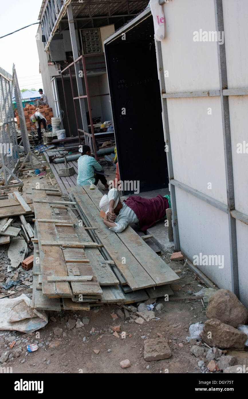 Un lavoratore edile è a riposo in un nuovo edificio sito in Kampong Cham, Cambogia. Foto Stock