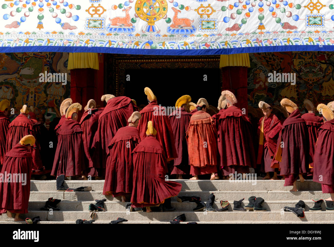 Monaci Tibetani indossando abiti e cappelli giallo dell'ordine Gelug o cappello giallo setta sulle scale di fronte all'Assembly Hall Foto Stock