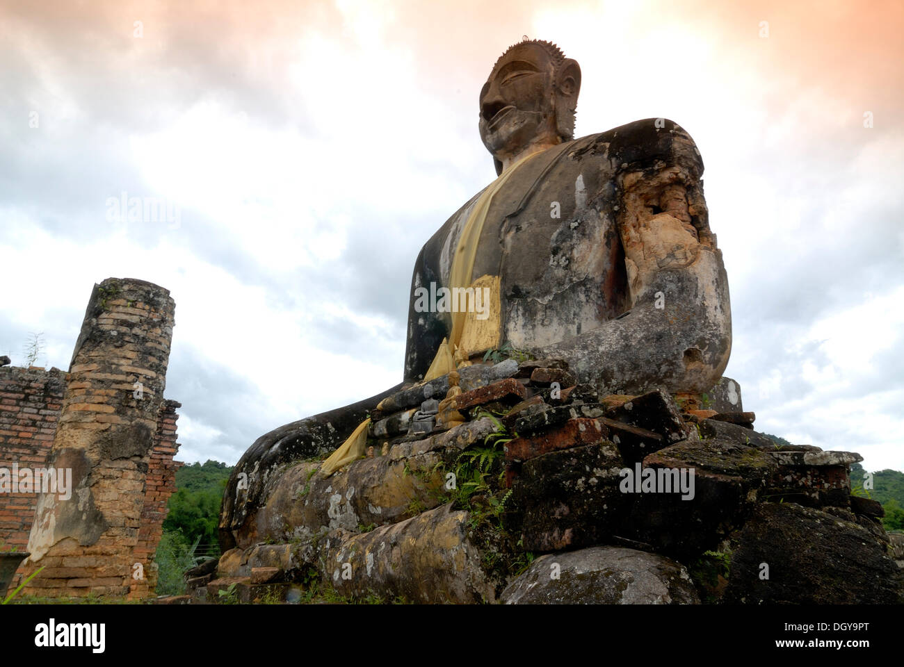 Coperte di fuliggine statua del Buddha del tempio buddista di Wat Phia Wat che fu bombardata nel 1966 durante la Guerra del Vietnam, Muang Khun Foto Stock