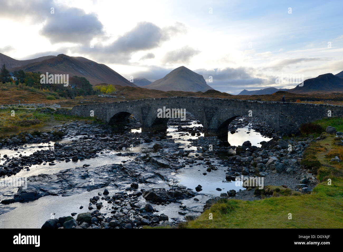 Un antico ponte in pietra di fronte al nero monti Cullins, Sligachan, Isola di Skye in Scozia, Regno Unito, Europa Foto Stock